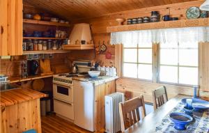 - une cuisine avec une cuisinière et une table dans une cabine dans l'établissement 4 Bedroom Stunning Home In Vinstra, à Vinstra