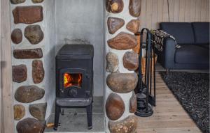 a stone wall with a stove in a living room at Beautiful Home In Ustaoset With House A Mountain View in Ustaoset