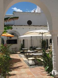 a patio area with a table, chairs, and an umbrella at Hotel Residencia Miami in Torremolinos