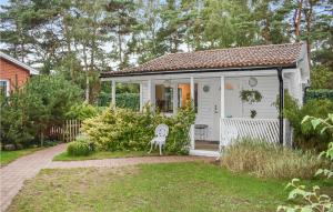 a small white cottage with a chair in the yard at 1 Bedroom Amazing Home In Hllviken in Höllviken