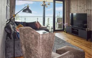 a living room with a couch and a television at Awesome Apartment In Noresund With Wifi in Noresund