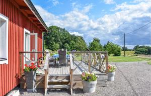 a deck with two chairs and flowers on a red building at Gorgeous Home In Billesholm With Kitchen in Billesholm