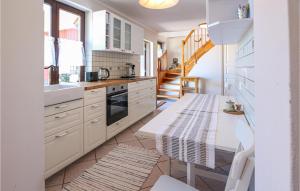 a kitchen with white cabinets and a table at Amazing Home In Rydsgrd With Kitchen in Rydsgård