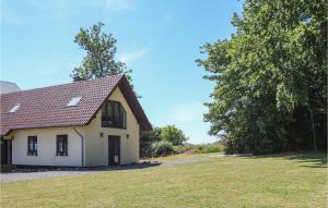 Biały dom z drzewem i trawnikiem w obiekcie Amazing Home In Rydsgrd With Kitchen w mieście Rydsgård