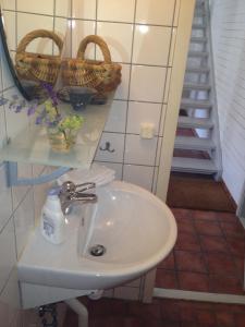 baño con lavabo, espejo y escaleras en Säbyholms Gård en Laholm