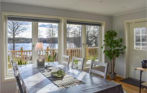 comedor con mesa, sillas y ventanas en Stunning Home In Backaryd With House Sea View, en Backaryd