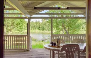 a porch with a table and chairs and a view of a lake at Awesome Home In Kallinge With 1 Bedrooms And Sauna in Kallinge