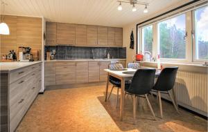 a kitchen with wooden cabinets and a table and chairs at 5 Bedroom Lovely Home In Sknes Fagerhult in Skånes Fagerhult