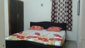 um quarto com uma cama com almofadas vermelhas em GIRI Service Apartment em Tirupati