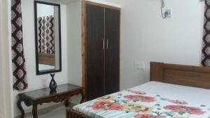 a bedroom with a bed with a dresser and a mirror at GIRI Service Apartment in Tirupati