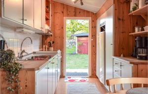 una cocina con fregadero y una puerta a un patio en 3 Bedroom Lovely Home In Torhamn, en Torhamn
