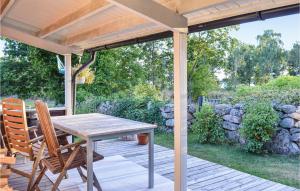 a wooden deck with a table and chairs on it at 3 Bedroom Lovely Home In Torhamn in Torhamn +11 photos