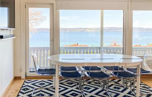 een witte eettafel met stoelen en uitzicht op het water bij 3 Bedroom Gorgeous Home In Bankeryd in Bankeryd