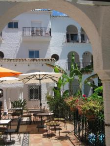 zewnętrzne patio ze stołami i parasolami oraz budynek w obiekcie Hotel Residencia Miami w mieście Torremolinos