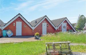 een rood huis met een terras ervoor bij Lovely Home In Sgne With Wifi in Søgne