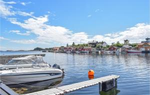 a boat is docked at a dock in the water at Lovely Home In Sgne With Wifi in Søgne