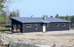 een groot zwart gebouw met een garage bij Beautiful Home In Vstervik With Kitchen in Västervik