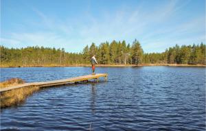 a man standing on a dock in the middle of a lake at Gorgeous Home In Kosta With Wifi in Kosta