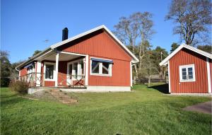 ein rotes Haus mit einem grünen Hof in der Unterkunft Cozy Home In Rockneby With Kitchen in Rockneby