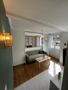 a living room with a couch and a table at LA VERRIÈRE. Les Locations ISAHORA c'est aussi plusieurs appart' de Standing à 2 pas du Château d'Eu, des Falaises du Tréport, de MERS les Bains et aux portes de la BAIE DE SOMME in Eu