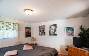1 dormitorio con 1 cama y cuadros en la pared en Awesome Home In Slite With Kitchenette en Slite