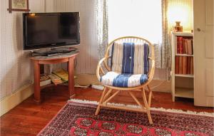 une chaise assise dans une pièce avec télévision dans l'établissement 1 Bedroom Gorgeous Home In Gnisvrd, à Gnisvärd