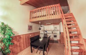 a kitchen and dining room with a wooden staircase and a table and chairs at 3 Bedroom Awesome Home In Sysslebäck in Branäs