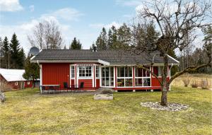 a red house with a picnic table in a yard at 3 Bedroom Beautiful Home In Ambjrnarp in Ambjörnarp