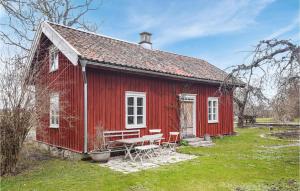 una casa roja con una mesa de picnic delante de ella en Amazing Home In Lidkping With Kitchen en Lidköping