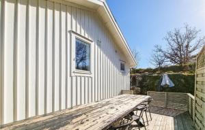 a wooden picnic table sitting next to a building at Nice Home In Skrhamn With Wifi And 2 Bedrooms in Skärhamn