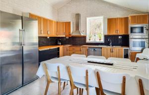 a kitchen with a white table and a refrigerator at Gorgeous Home In Skrhamn With Wifi in Skärhamn