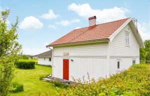 a white barn with a red door at Stunning Home In Svanesund With Wifi in Svanesund