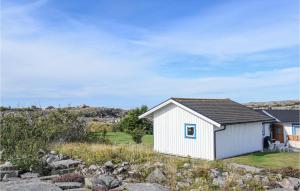 a small white shed on the side of a hill at 1 Bedroom Nice Home In Bohus-Malmön in Bohus-Malmön