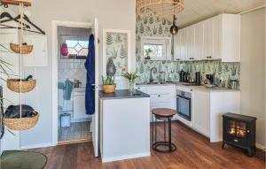 a kitchen with white cabinets and a stove at Amazing Home In Vänersnäs With Wifi in Hallby