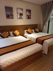 um quarto de hotel com duas camas e pinturas na parede em Apec 5 sao TP.Tuy Hòa - View biển và view hồ bơi em Ðông Tác (1)