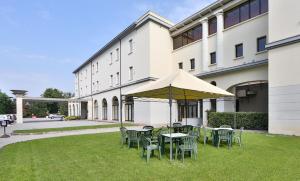 un groupe de tables et de chaises sous un parapluie dans l'établissement Hotel San Marco & Formula Club, à Noceto