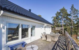 a deck with chairs and tables on a house at 2 Bedroom Lovely Home In Uddevalla in Uddevalla