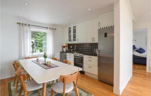 cocina con mesa, sillas y nevera en Awesome Home In Mellerud With Lake View, en Mellerud