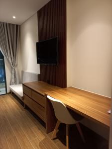 a room with a desk and a tv on a wall at Apec 5 sao TP.Tuy Hòa - View biển và view hồ bơi in Ðông Tác (1)