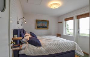 1 dormitorio con 1 cama grande con almohadas azules en Awesome Home In Mellerud With Lake View, en Mellerud