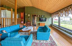 uma sala de estar com sofás azuis e uma mesa em Amazing Home In Hviksns With Kitchen em Höviksnäs