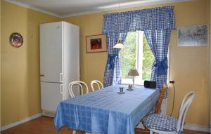 a dining room table with a blue tablecloth and a window at Awesome Apartment In Rnneshytta With Kitchen in Rönneshytta