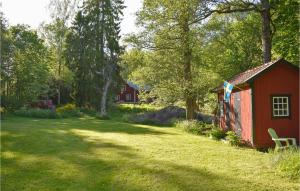 a red barn in the middle of a yard at Stunning Apartment In Rönneshytta in Rönneshytta +14 photos
