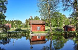 a small red house sitting on top of a lake at Awesome Apartment In Rnneshytta With 1 Bedrooms in Rönneshytta