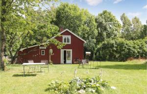 a red barn with a picnic table in the yard at Cozy Home In Dals-Rostock With Kitchen in Dals Rostock