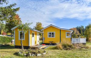 a yellow tiny house in a yard at Nice Home In Kolmrden With Kitchenette in Kolmården