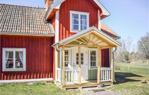 une maison rouge avec une porte blanche et des fenêtres dans l'établissement Stunning Home In deshg With Wifi, à Ödeshög