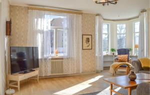 Amazing Home In Nynshamn With Kitchen في نينس هامن: غرفة معيشة مع تلفزيون بشاشة مسطحة ونوافذ