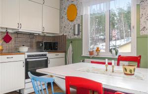 a kitchen with red chairs and a white counter top at 3 Bedroom Awesome Home In Arvika in Arvika