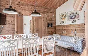 una sala de estar con paredes de madera y muebles blancos. en Cozy Apartment In Sysslebck With Wifi en Sysslebäck